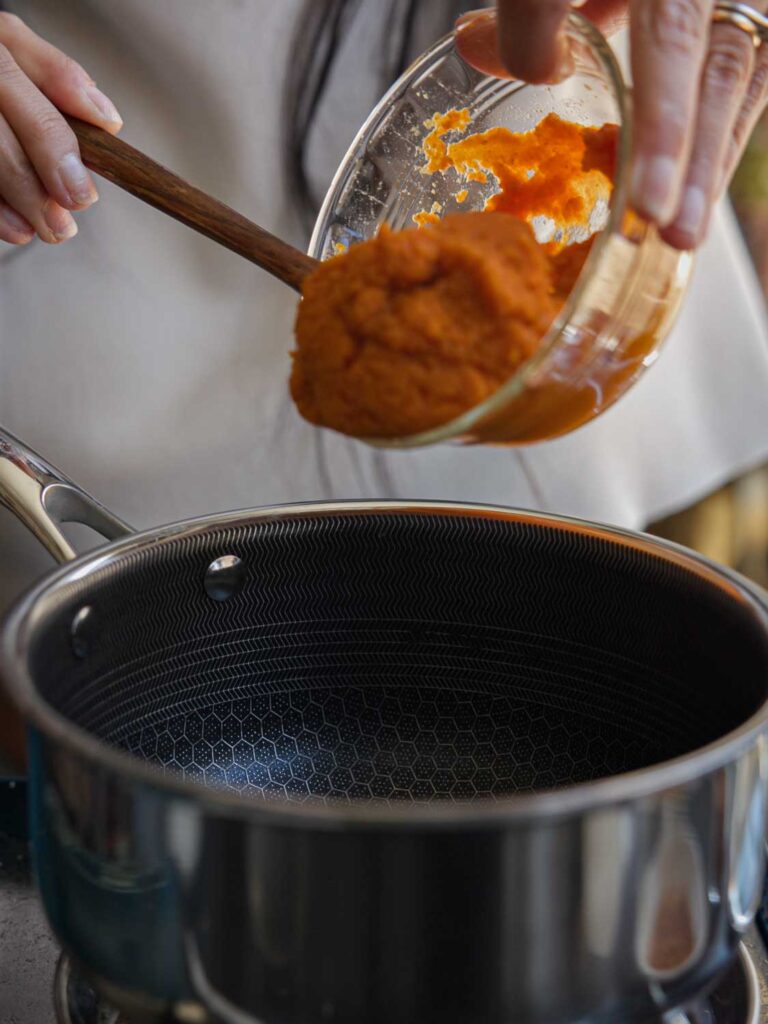 adding pumpkin puree to pot